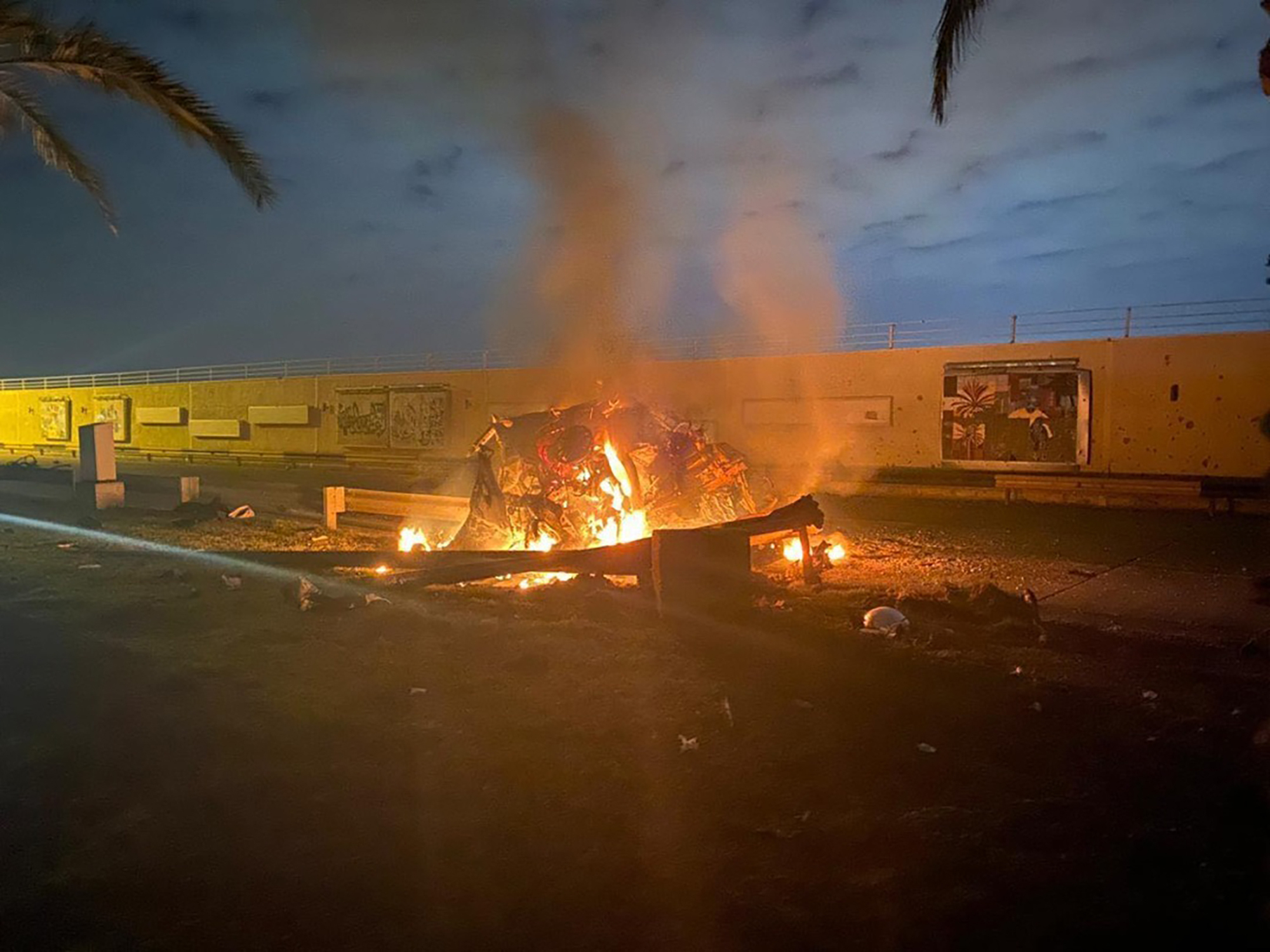 This photo released by the Iraqi Prime Minister Press Office shows a burning vehicle at the Baghdad International Airport following an airstrike in Baghdad, Iraq, early Friday.