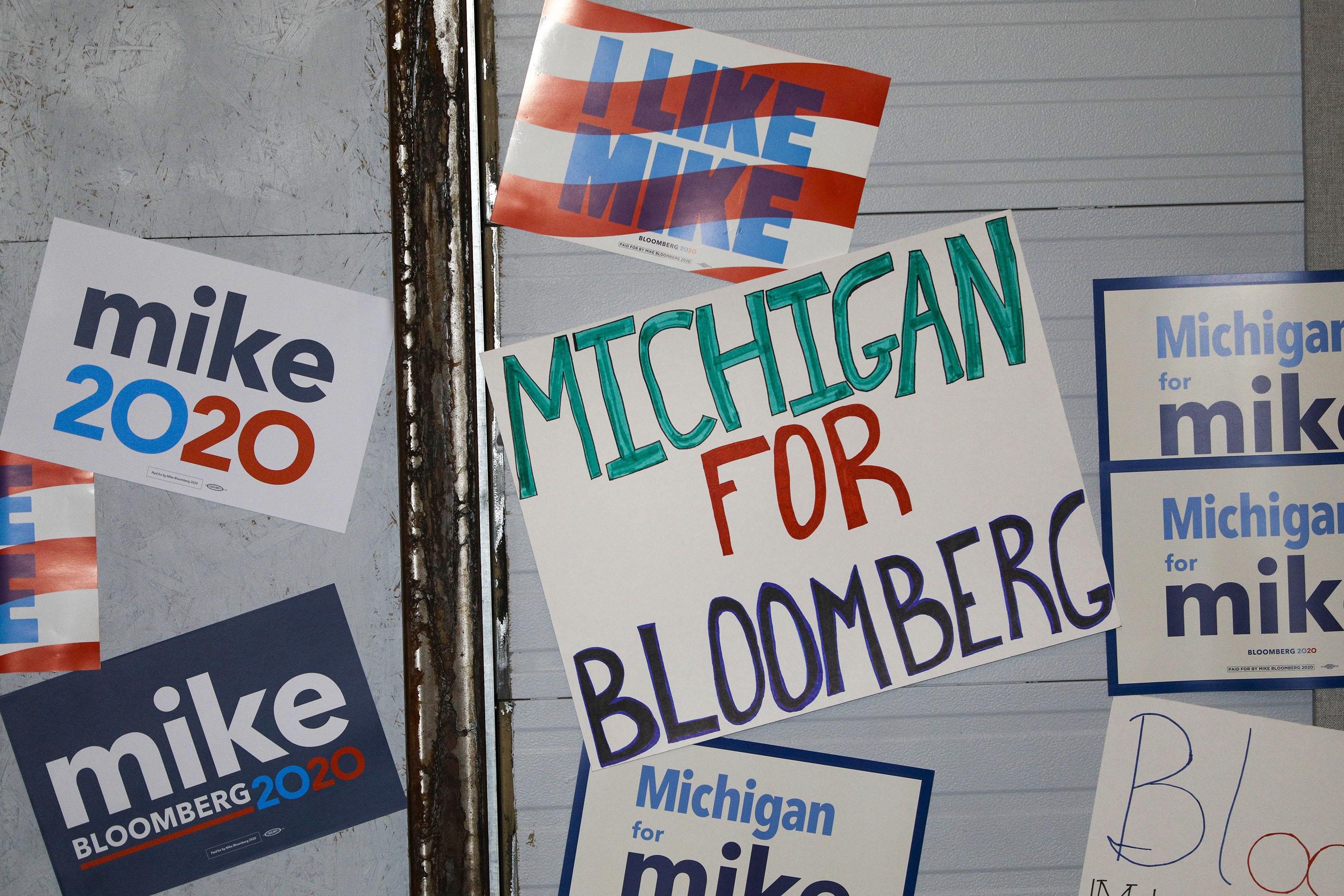 Signs are posted on a wall at a rally site where Democratic presidential candidate Mike Bloomberg held a campaign rally on Feb. 4