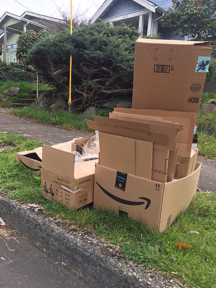 After delivery, Amazon shipping cartons await city recycling pickup on a curbside in Southeast Seattle.