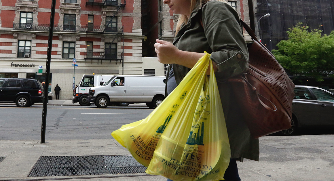 A person carrying plastic bags | AP Photo