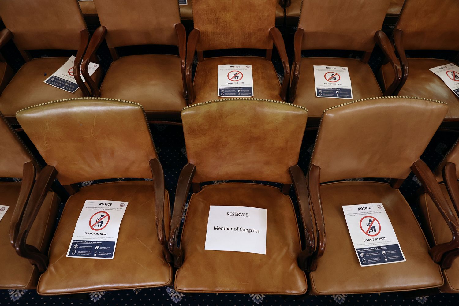 Signs tell members of Congress where to sit so to follow social distancing guidelines during a hearing. 