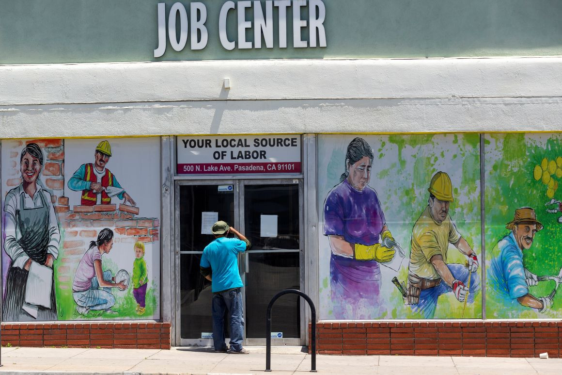A person looks inside the closed doors of the Pasadena Community Job Center in California. | AP Photo