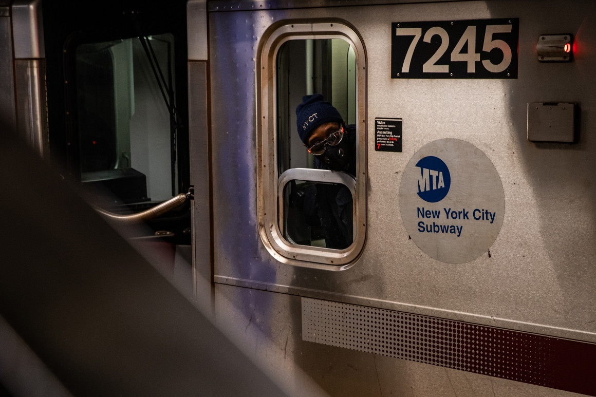 A conductor wearing a protective mask is seen on a subway platform in New York City. | Getty Images
